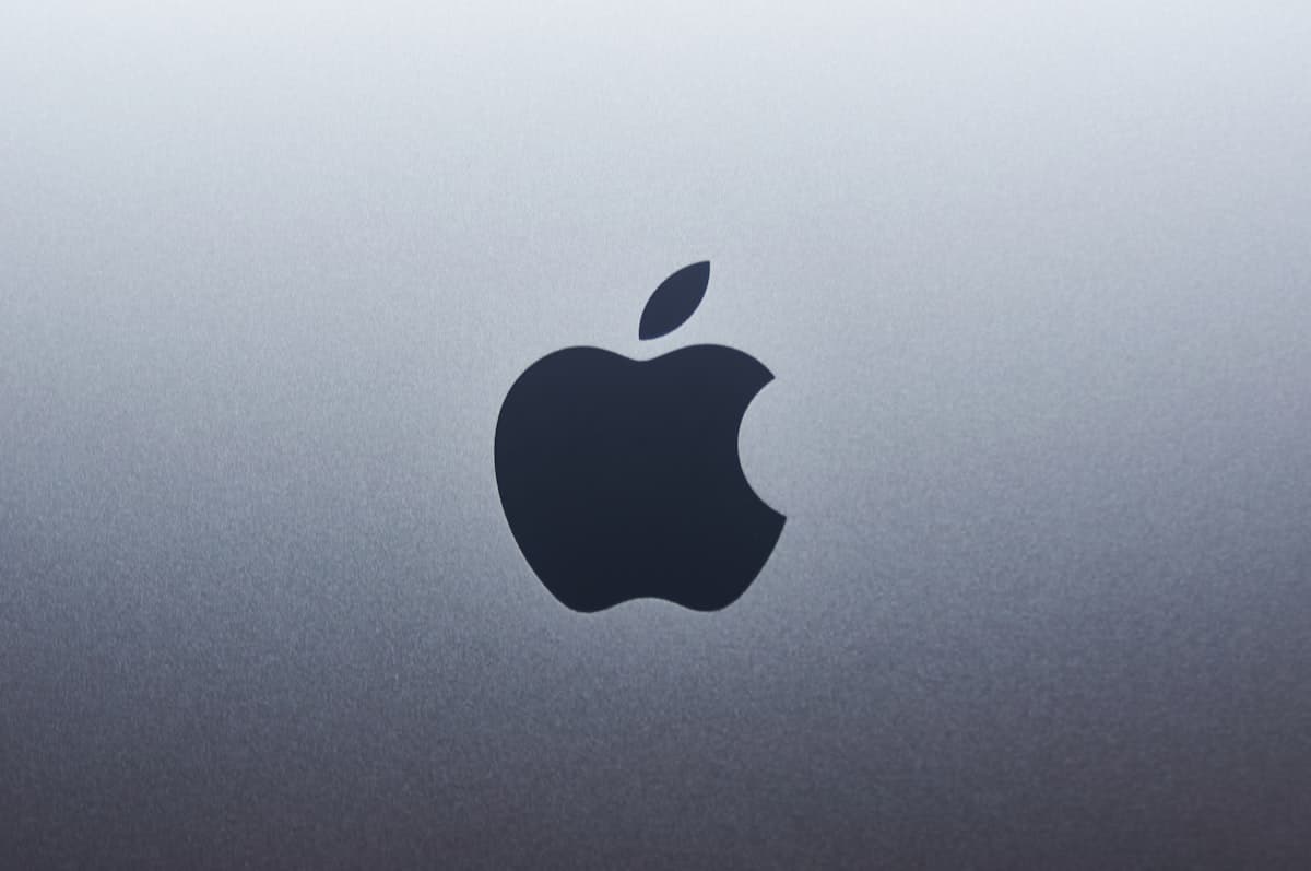 Logo de Apple iluminado en un entorno minimalista representando la estrategia de inteligencia artificial de la empresa