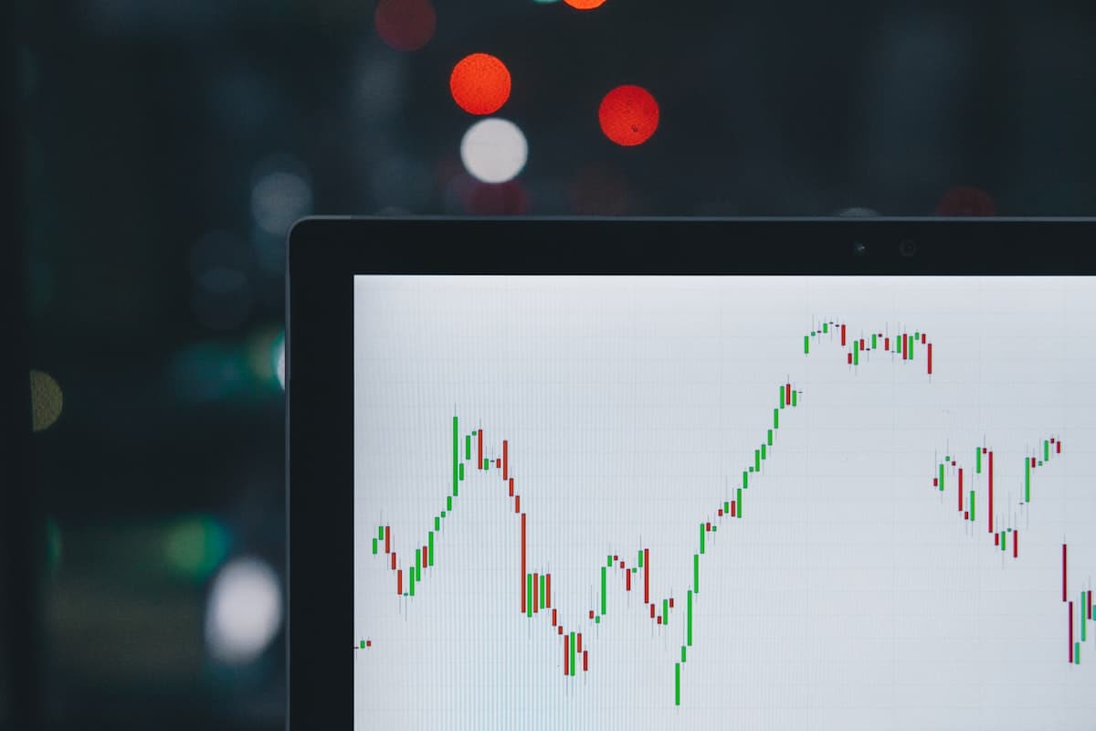 Stock market candlestick chart showing a steep downward trend with red candles on a dark background