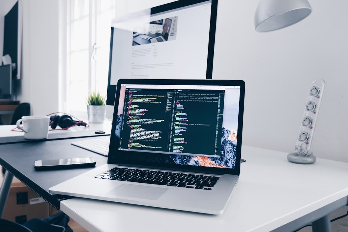 MacBook laptop displaying code in a developer workspace